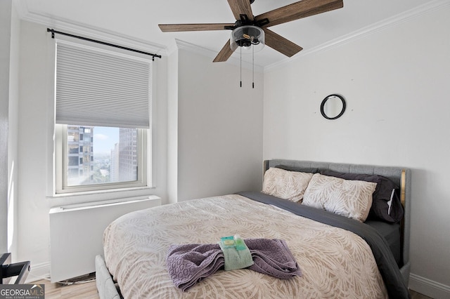 bedroom with light hardwood / wood-style flooring, ornamental molding, and ceiling fan