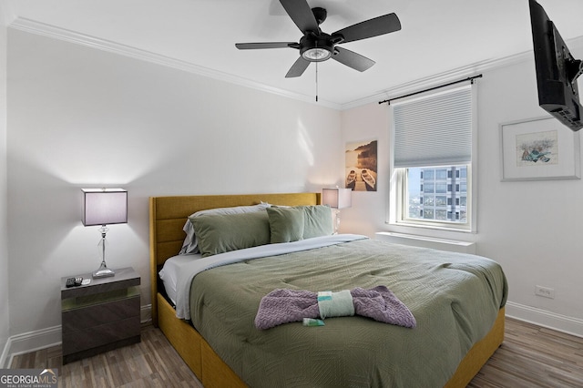 bedroom featuring crown molding, wood-type flooring, and ceiling fan