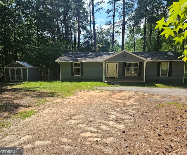 single story home featuring a storage shed and a porch