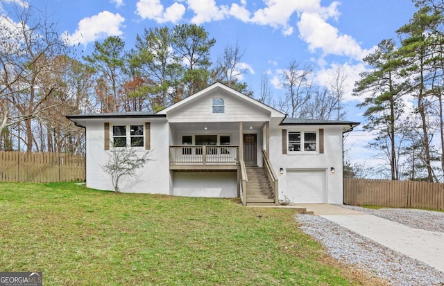 view of front of house with a garage, a front yard, and a porch