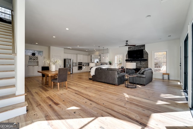 living room with ceiling fan and light hardwood / wood-style floors