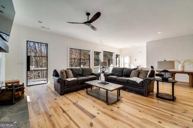 living room featuring ceiling fan and light wood-type flooring