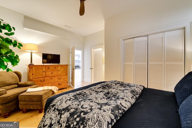 bedroom with hardwood / wood-style floors, a closet, and ceiling fan