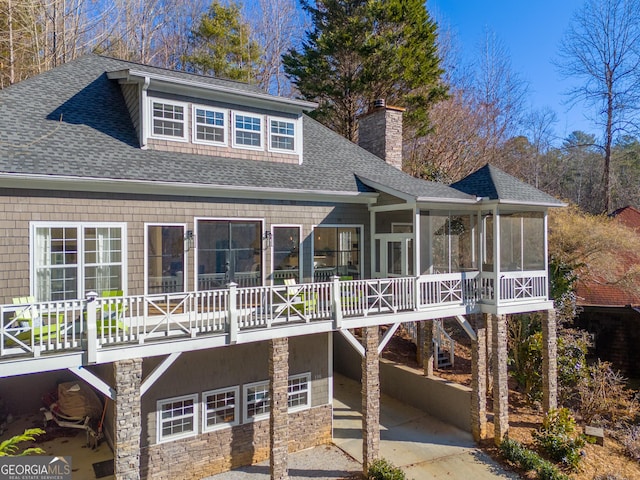 back of house with a garage and a sunroom