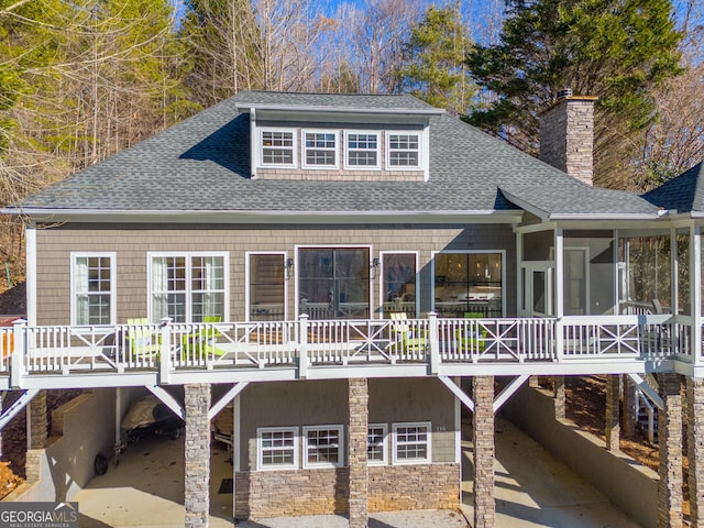 back of property with a carport and a sunroom