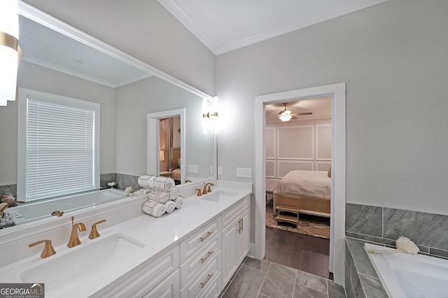 bathroom with ornamental molding, vanity, and tiled tub