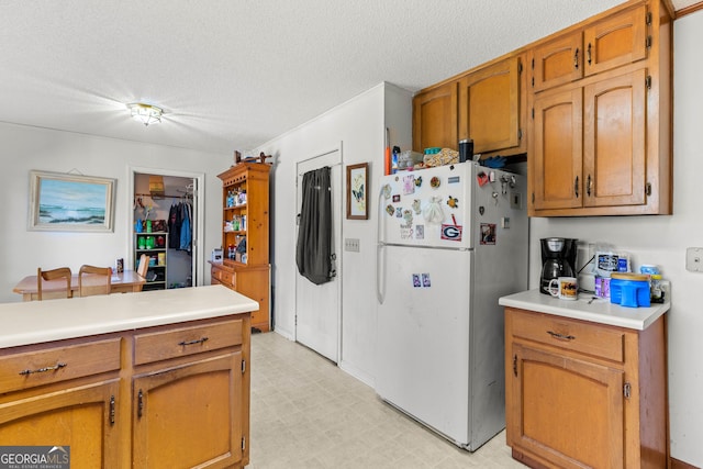 kitchen with white fridge and a textured ceiling