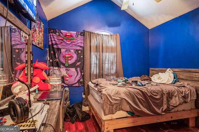 bedroom featuring hardwood / wood-style flooring, ceiling fan, vaulted ceiling, and a textured ceiling