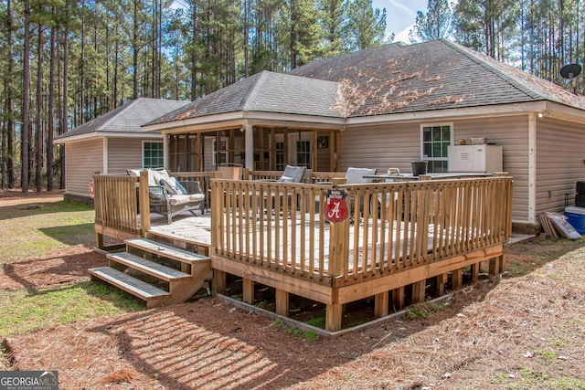 rear view of house with a deck and a sunroom