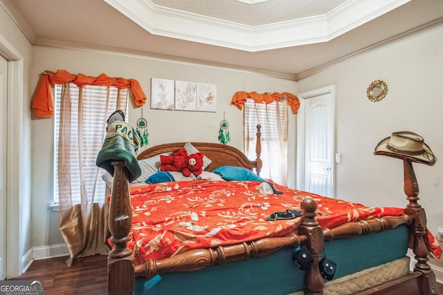 bedroom featuring multiple windows, hardwood / wood-style floors, ornamental molding, and a textured ceiling