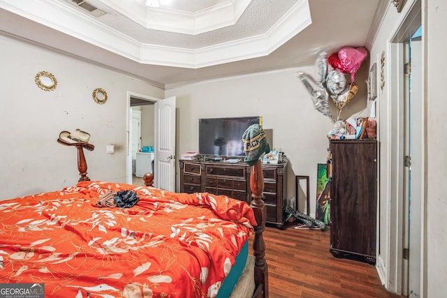 bedroom featuring crown molding, a raised ceiling, dark wood-type flooring, and a textured ceiling