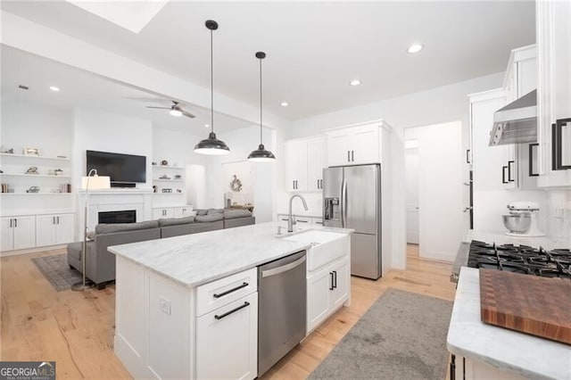 kitchen with white cabinetry, stainless steel appliances, and a kitchen island with sink