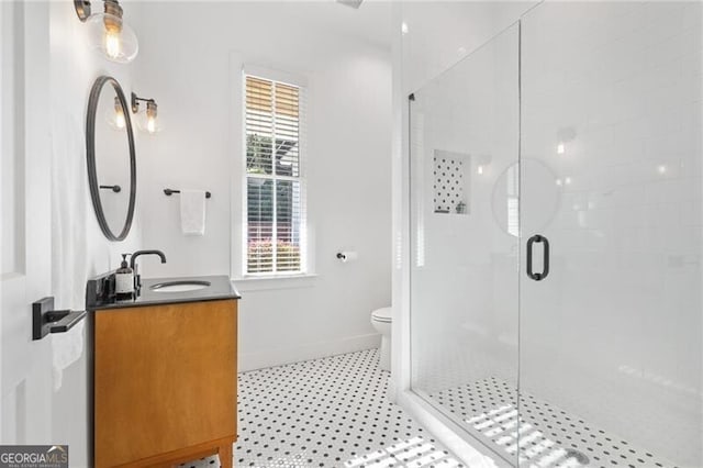 bathroom with walk in shower, vanity, and toilet