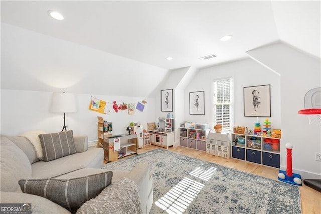 recreation room featuring hardwood / wood-style floors and vaulted ceiling