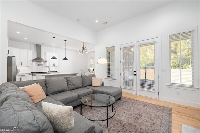 living room featuring an inviting chandelier and light wood-type flooring