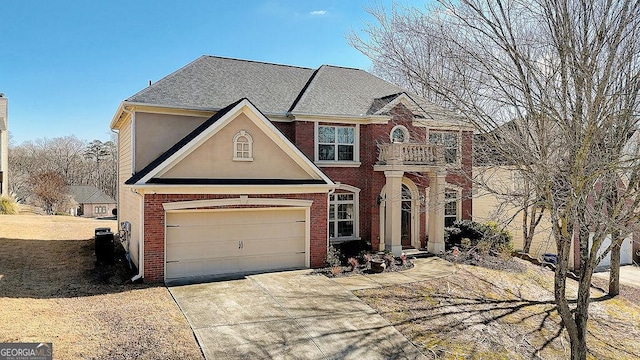 view of front of house with brick siding, roof with shingles, stucco siding, a balcony, and driveway