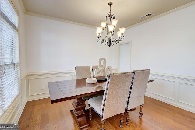 dining space with visible vents, a wealth of natural light, and ornamental molding