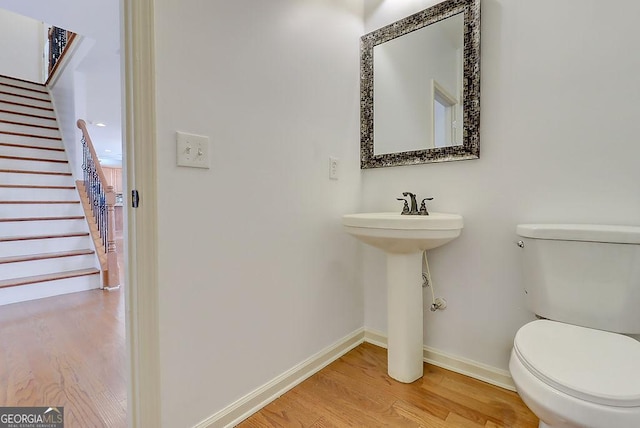 bathroom featuring baseboards, toilet, and wood finished floors