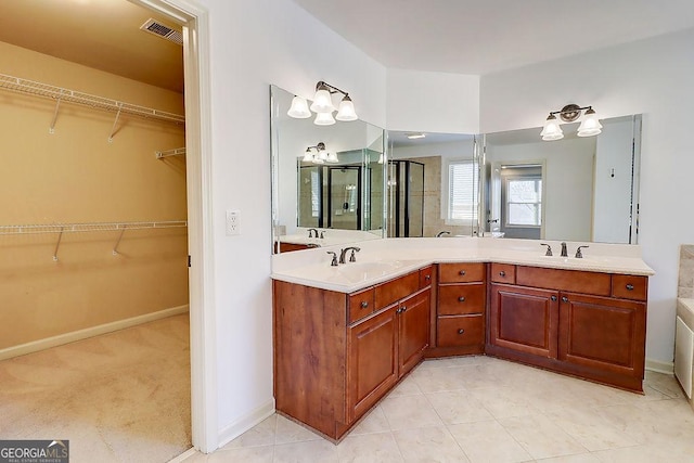 full bathroom with visible vents, double vanity, a stall shower, a sink, and a spacious closet