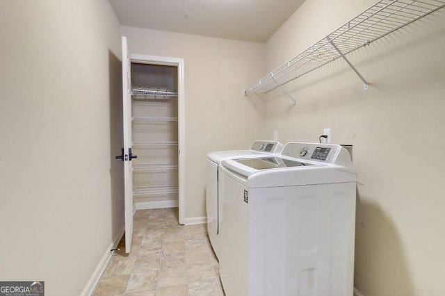 washroom featuring baseboards, separate washer and dryer, and laundry area