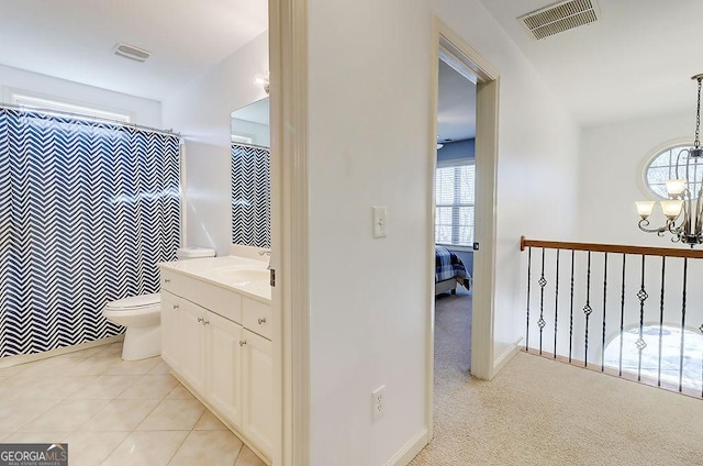 ensuite bathroom featuring vanity, toilet, a notable chandelier, and visible vents