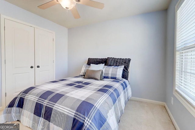 carpeted bedroom featuring a closet, a ceiling fan, and baseboards