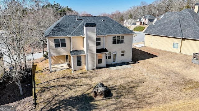 rear view of property featuring a shingled roof