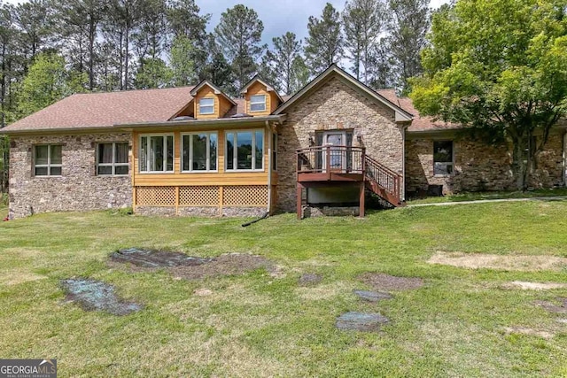 back of house with a wooden deck and a lawn