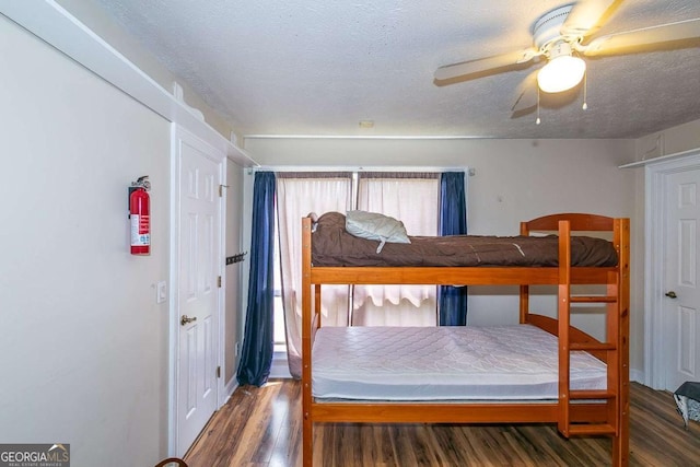 bedroom featuring ceiling fan, hardwood / wood-style flooring, and a textured ceiling