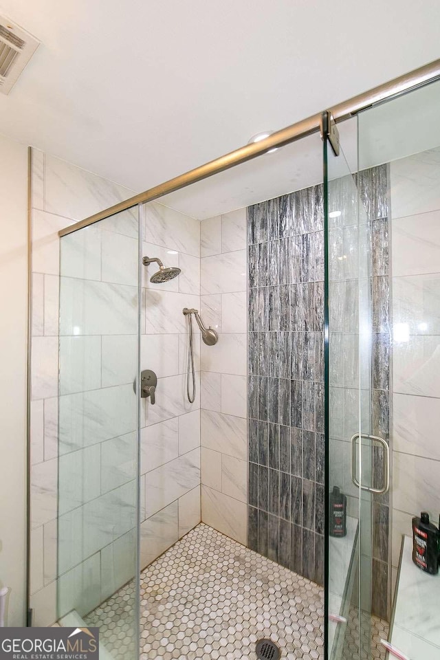 bathroom with a shower with door