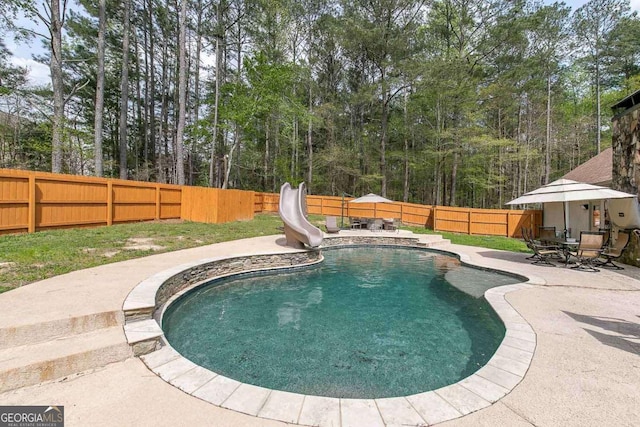 view of swimming pool with a water slide and a patio area