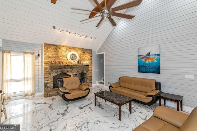 living room featuring ceiling fan, lofted ceiling, rail lighting, and a fireplace