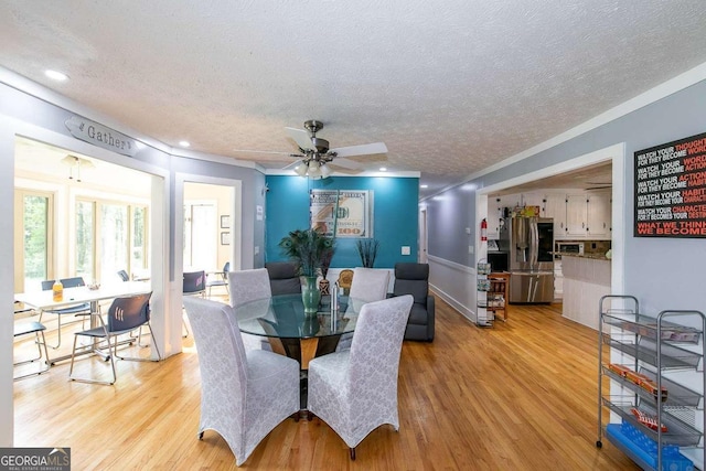 dining room with ceiling fan, a textured ceiling, and light hardwood / wood-style flooring