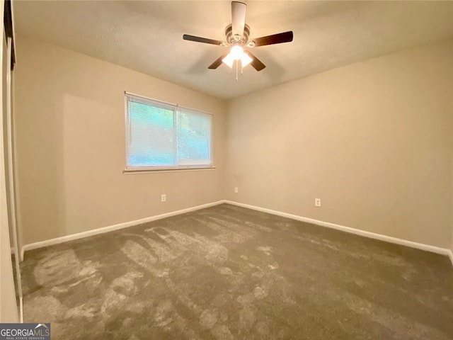 unfurnished room featuring ceiling fan and dark colored carpet