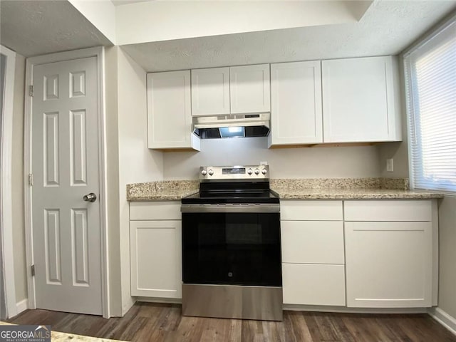 kitchen with stainless steel electric range, dark wood-type flooring, light stone countertops, and white cabinets