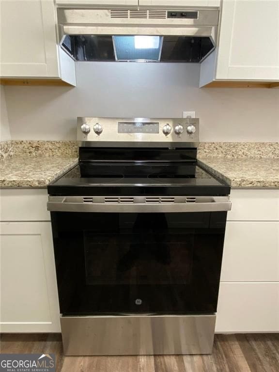 kitchen featuring white cabinetry, stainless steel electric range, and dark wood-type flooring