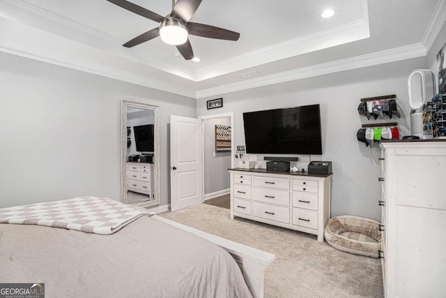 carpeted bedroom featuring a tray ceiling, ornamental molding, and ceiling fan