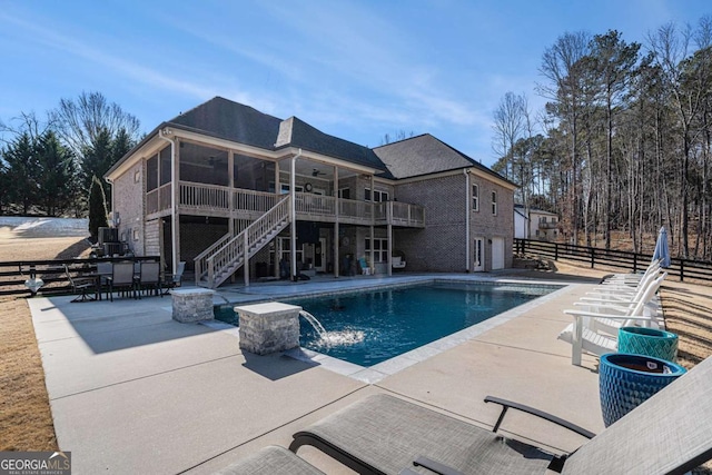 view of swimming pool featuring a patio, a sunroom, and pool water feature