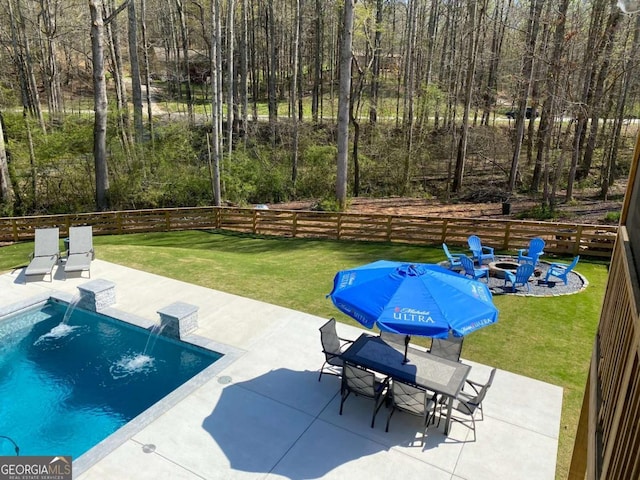 view of pool featuring a patio, pool water feature, a yard, and a fire pit