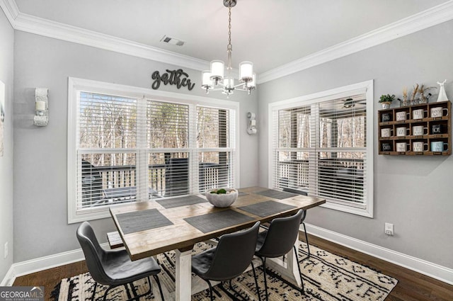 dining space featuring crown molding, hardwood / wood-style floors, and a notable chandelier