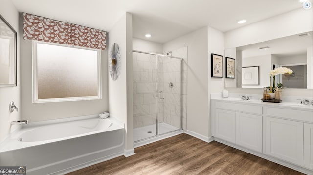 313 Sound Cir Unit 140, Stockbridge, GA 30281 - full bathroom featuring a stall shower, a bath, wood finished floors, double vanity, and recessed lighting