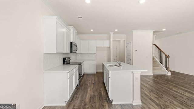 313 Sound Cir Unit 140, Stockbridge, GA 30281 - kitchen with stainless steel appliances, a sink, white cabinets, decorative backsplash, and dark wood finished floors