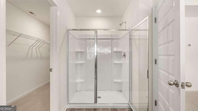 313 Sound Cir Unit 140, Stockbridge, GA 30281 - bathroom with a shower stall, a spacious closet, and baseboards