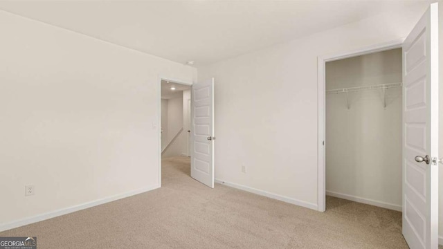 313 Sound Cir Unit 140, Stockbridge, GA 30281 - unfurnished bedroom featuring light colored carpet, baseboards, and a closet