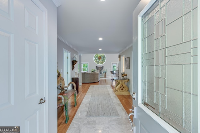 foyer with light hardwood / wood-style flooring and crown molding