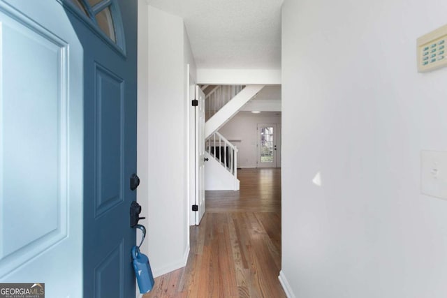 foyer with wood-type flooring and a textured ceiling