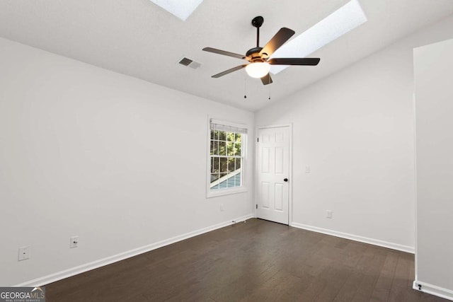 spare room featuring ceiling fan, lofted ceiling with skylight, and dark hardwood / wood-style flooring