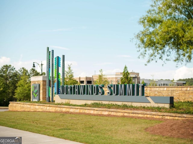 community / neighborhood sign featuring a lawn