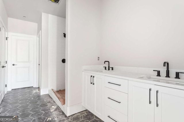 bathroom with vanity, tile patterned floors, and a tile shower