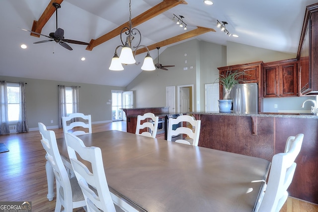 dining area featuring high vaulted ceiling, track lighting, beamed ceiling, ceiling fan, and light hardwood / wood-style floors